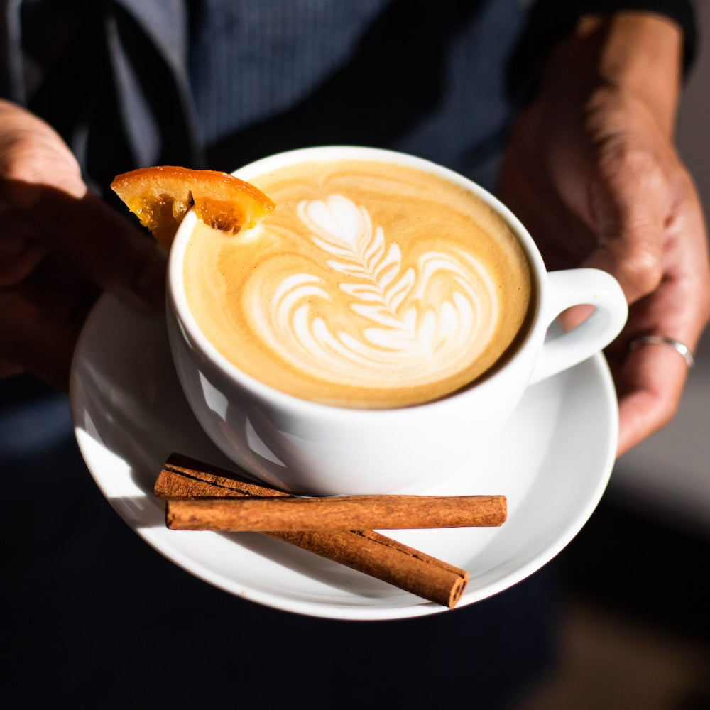 crema's lutito latte being held by a barista