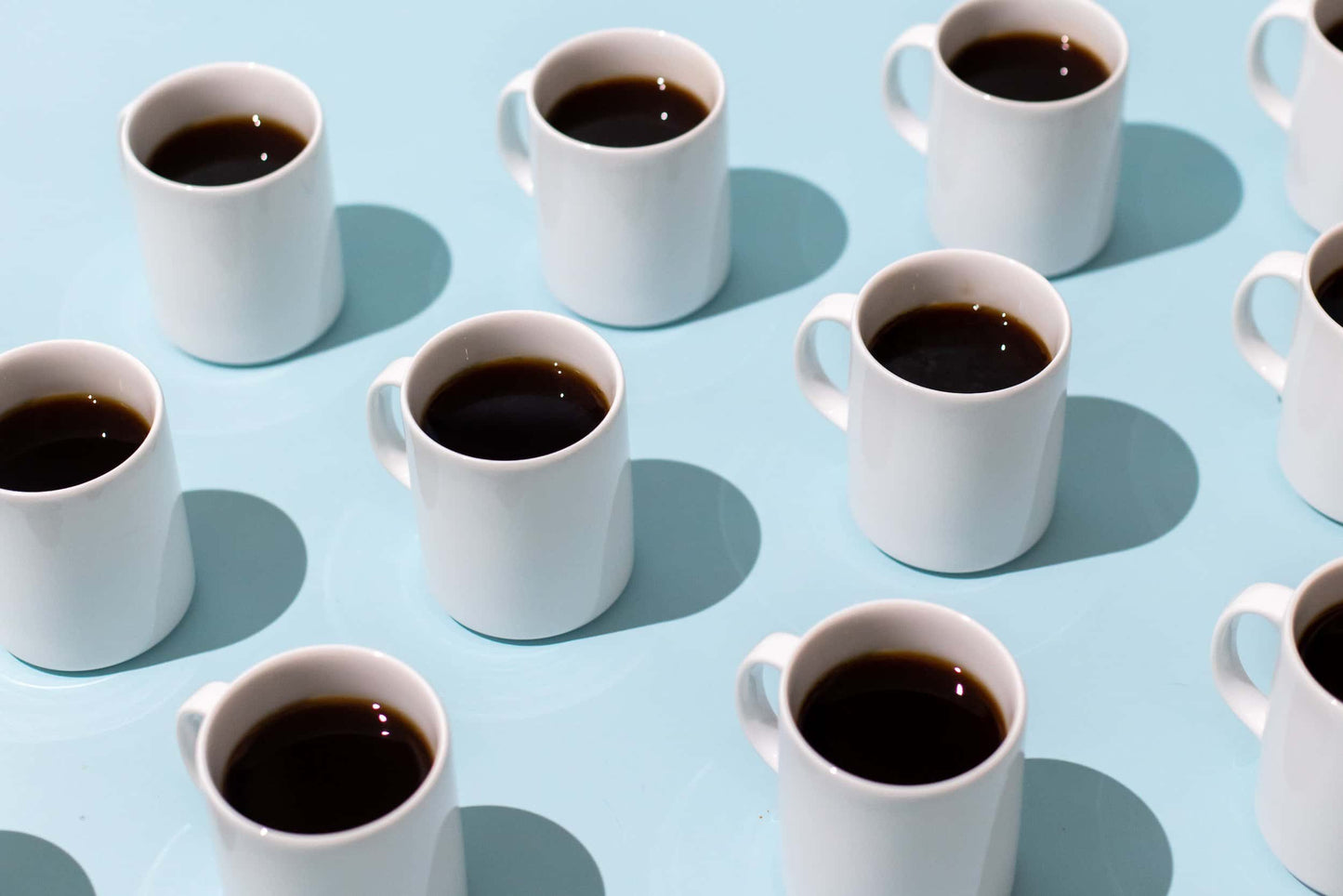 cups of coffee lined up on blue background